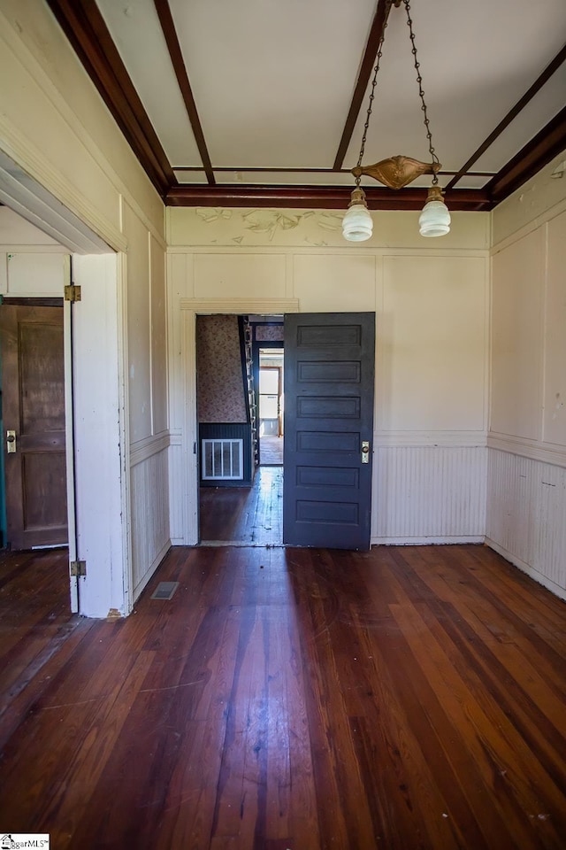 spare room with ornamental molding and dark wood-type flooring