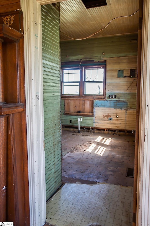 bathroom featuring wooden walls and tile flooring