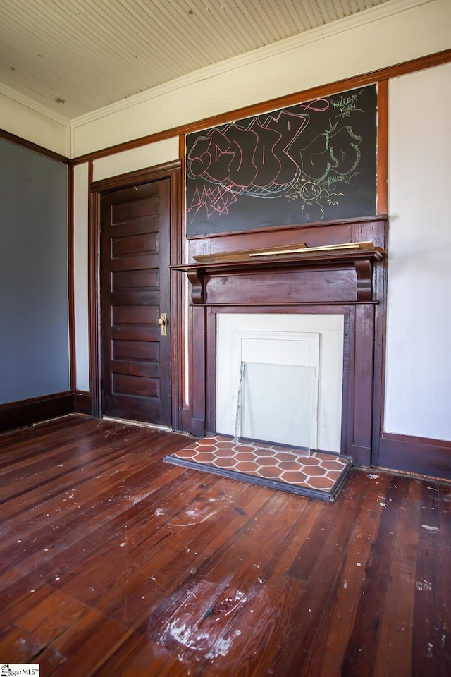 unfurnished living room featuring crown molding and dark wood-type flooring