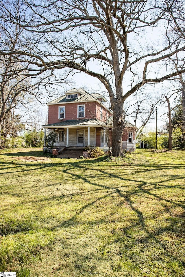 view of front of home with a front yard and covered porch