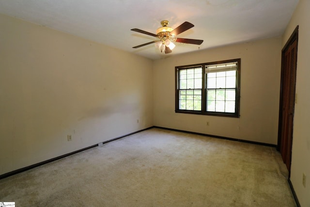 spare room featuring ceiling fan and light colored carpet