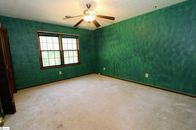 spare room featuring ceiling fan and light carpet