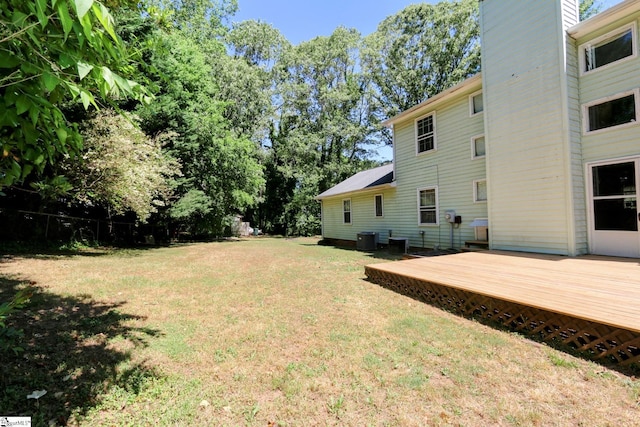 view of yard with a deck and central AC unit