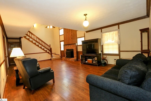 living room with a fireplace, crown molding, and dark wood-type flooring