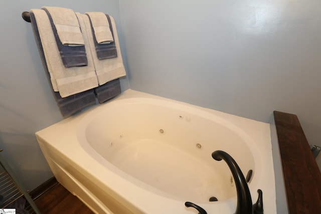 bathroom with hardwood / wood-style flooring and a tub