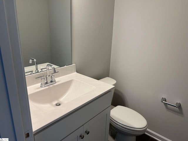 bathroom with toilet and vanity with extensive cabinet space