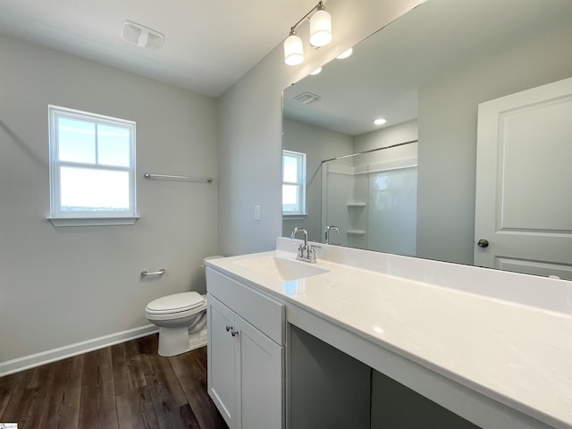 bathroom with toilet, vanity with extensive cabinet space, and wood-type flooring