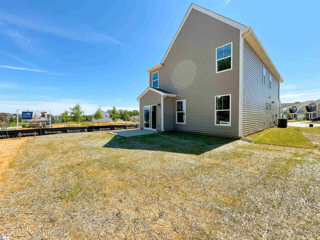 rear view of property featuring a yard, central AC, and a patio