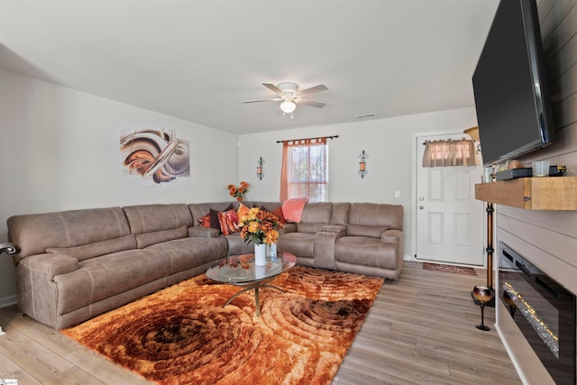 living room with light hardwood / wood-style floors and ceiling fan