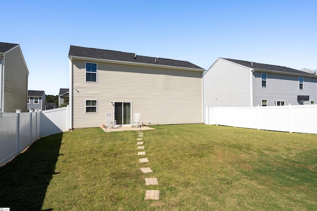 rear view of property featuring a patio and a yard