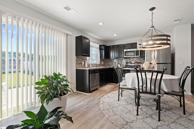 kitchen featuring decorative light fixtures, a chandelier, a wealth of natural light, and stainless steel appliances