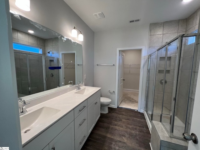 bathroom with walk in shower, wood-type flooring, and double sink