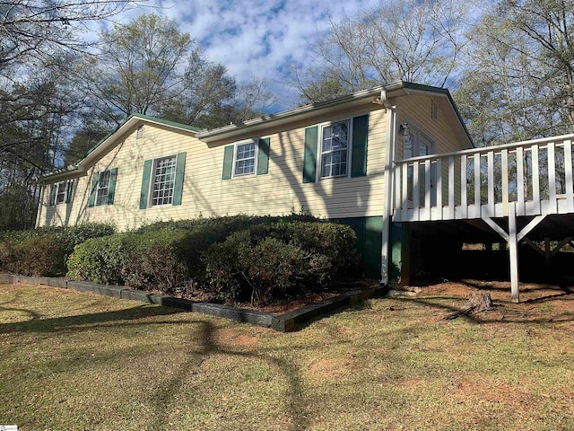 view of front of house with a deck and a front yard