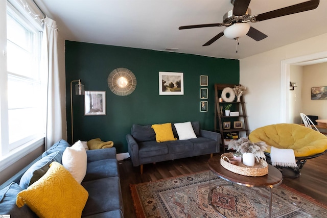 living room featuring dark wood-type flooring and ceiling fan