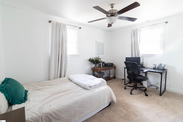 bedroom featuring multiple windows, light colored carpet, and ceiling fan