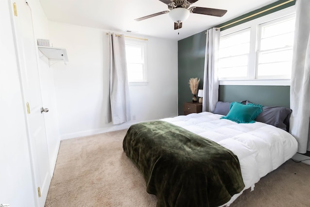 bedroom with light carpet, multiple windows, and ceiling fan