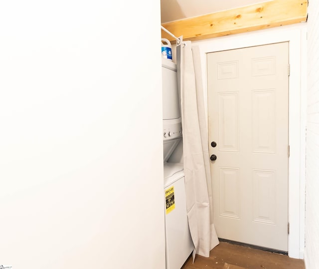 clothes washing area with stacked washing maching and dryer and dark hardwood / wood-style floors