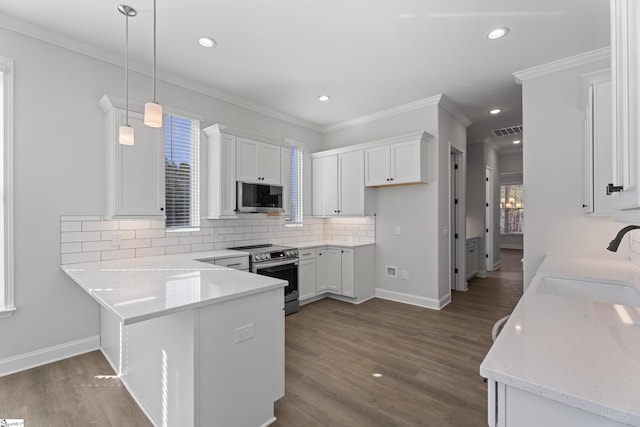 kitchen with visible vents, white cabinets, appliances with stainless steel finishes, hanging light fixtures, and a sink