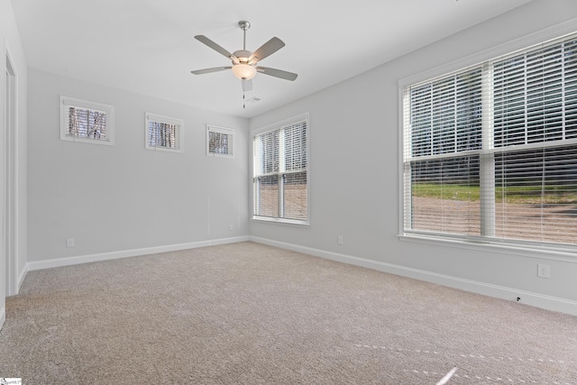 carpeted empty room featuring ceiling fan and baseboards