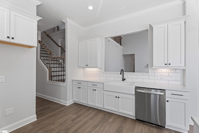 kitchen with baseboards, white cabinets, dishwasher, light countertops, and a sink