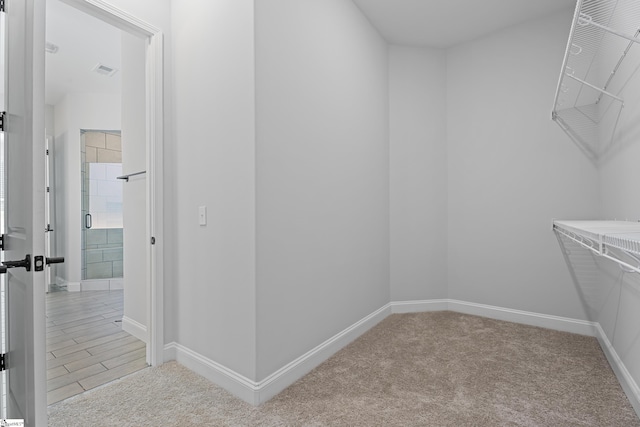 walk in closet featuring visible vents and light colored carpet