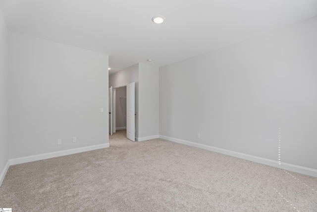 unfurnished room featuring recessed lighting, light colored carpet, and baseboards