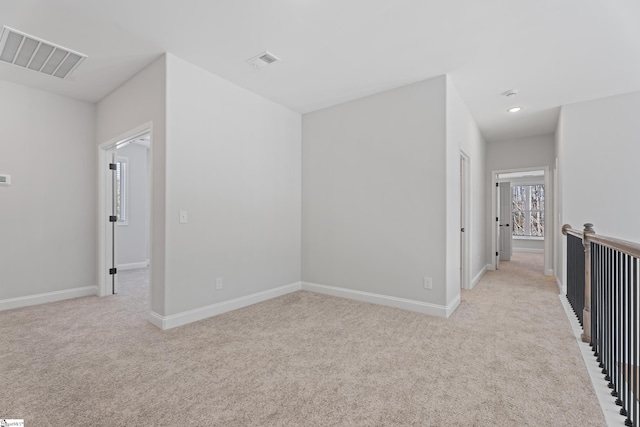 interior space featuring light carpet, baseboards, and visible vents