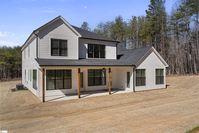 back of house with a shingled roof, a patio, and central air condition unit