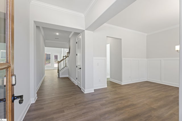 entrance foyer with dark wood-style flooring, crown molding, stairway, and a decorative wall