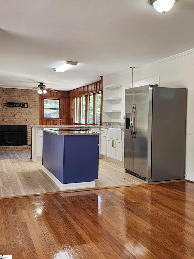 kitchen with stainless steel fridge with ice dispenser, ceiling fan, white cabinets, and light wood-type flooring