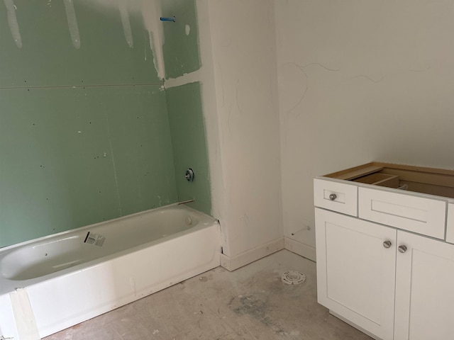 bathroom with concrete floors, a bathtub, and vanity