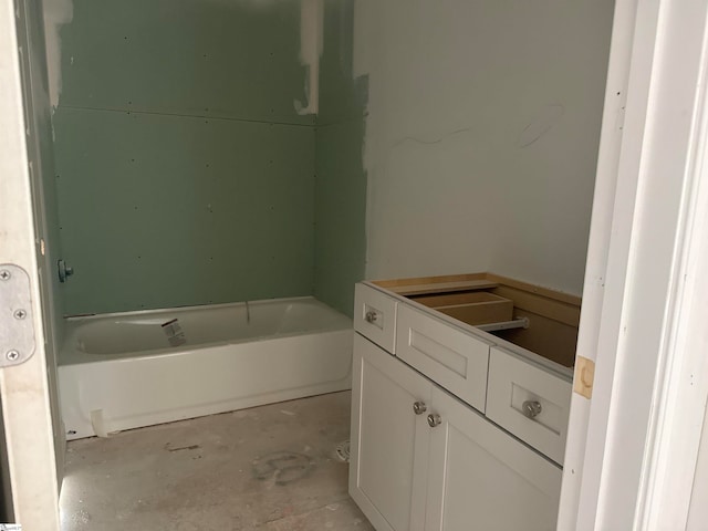 bathroom featuring concrete floors, a washtub, and vanity