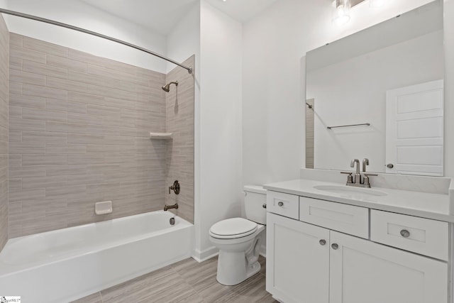 full bathroom featuring wood-type flooring, vanity, tiled shower / bath combo, and toilet