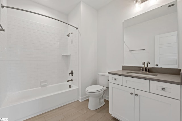 full bathroom with vanity, tiled shower / bath, and toilet