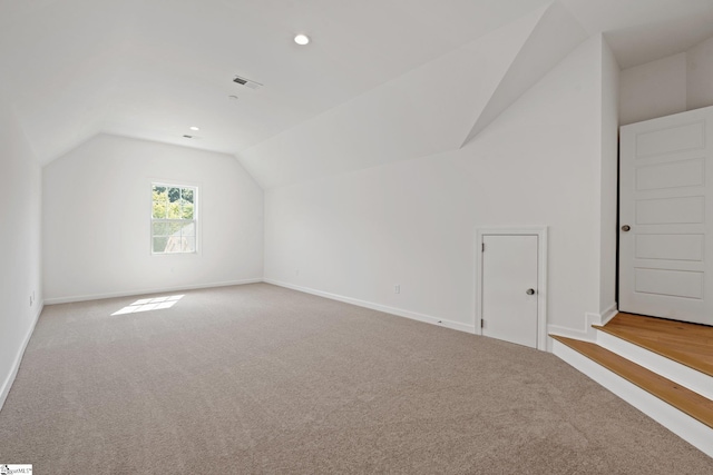 additional living space with lofted ceiling and light carpet