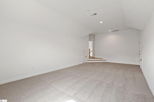 bonus room with lofted ceiling and light carpet