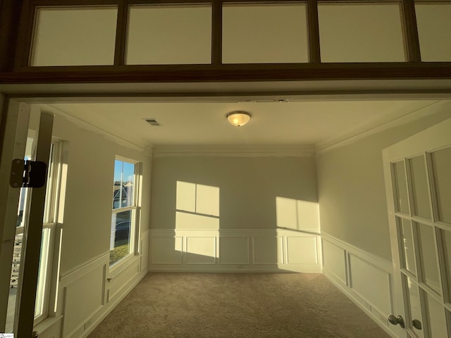 unfurnished room featuring crown molding and light carpet