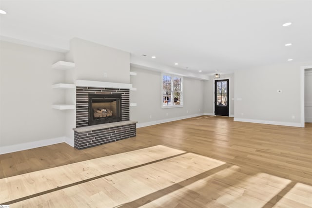 unfurnished living room featuring a fireplace and light hardwood / wood-style flooring