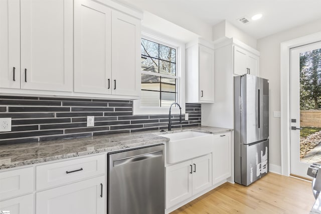 kitchen with white cabinets, appliances with stainless steel finishes, and sink