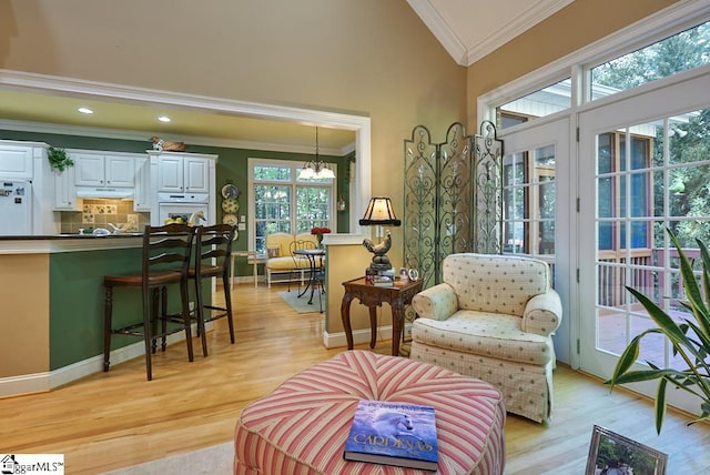 interior space featuring crown molding, light hardwood / wood-style floors, a notable chandelier, and vaulted ceiling