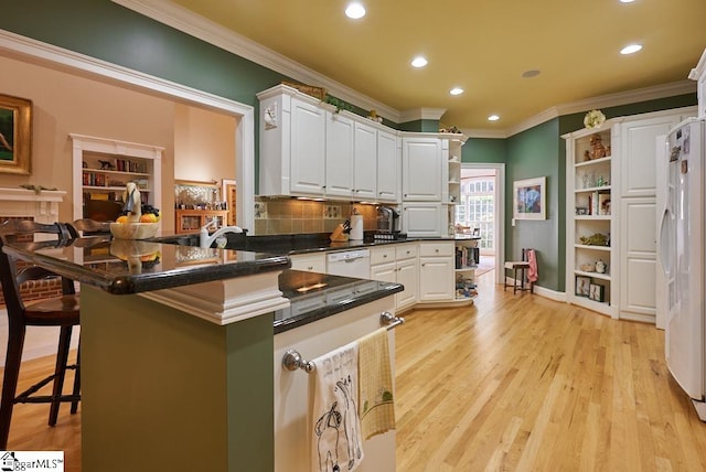 kitchen with white cabinetry, white appliances, a breakfast bar, light hardwood / wood-style flooring, and crown molding