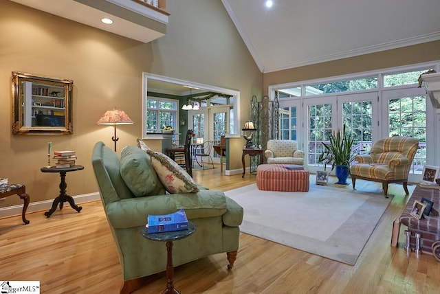 living room with crown molding, light wood-type flooring, high vaulted ceiling, and french doors