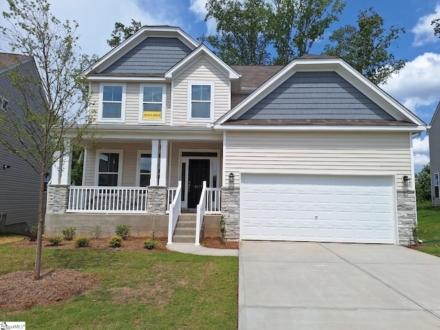 craftsman house with a garage, a front yard, and a porch