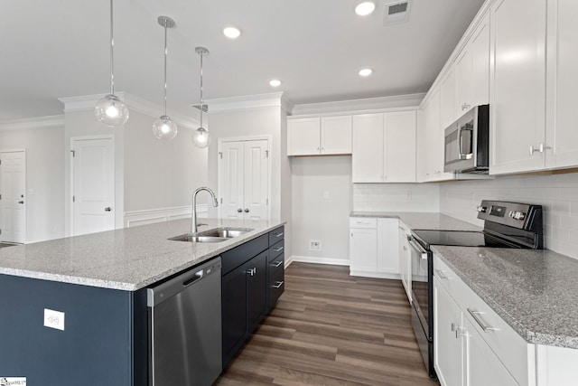 kitchen with stainless steel appliances, white cabinetry, a center island with sink, and decorative light fixtures