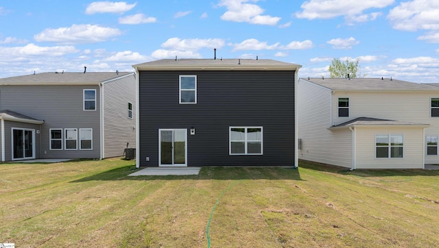 rear view of property featuring central air condition unit and a lawn