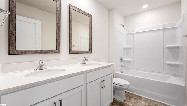 full bathroom featuring toilet, vanity, and washtub / shower combination