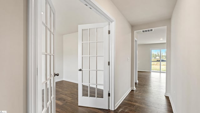 corridor featuring french doors and dark wood-type flooring