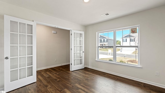 spare room with dark wood-type flooring and french doors