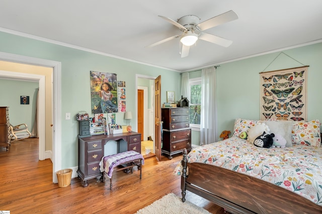 bedroom with crown molding, ceiling fan, and light hardwood / wood-style flooring