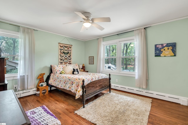 bedroom featuring hardwood / wood-style floors, crown molding, ceiling fan, and baseboard heating